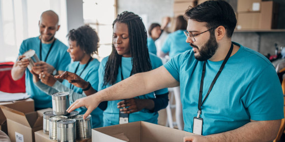 Diverse volunteers packing donation boxes in charity food bank