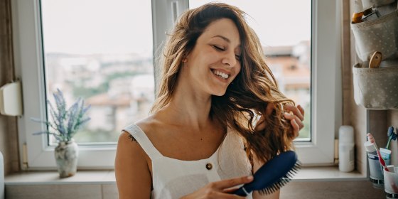 Young woman combing hair