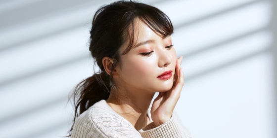 Beauty portrait of young Asian woman on the light and shadow background