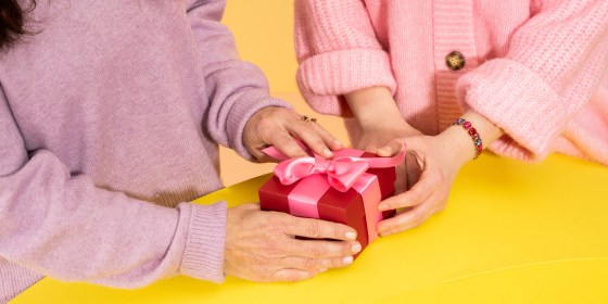 Two hands holding onto a gift basket