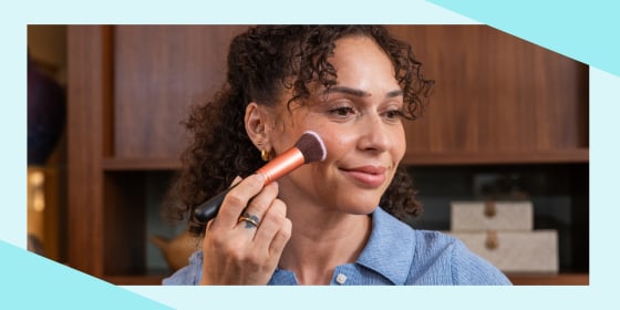 Woman applying makeup with a brush
