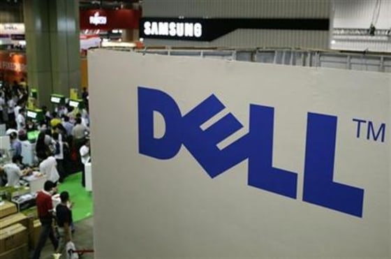 Shoppers walk past a Dell booth at the COMEX technology exhibition in Singapore.