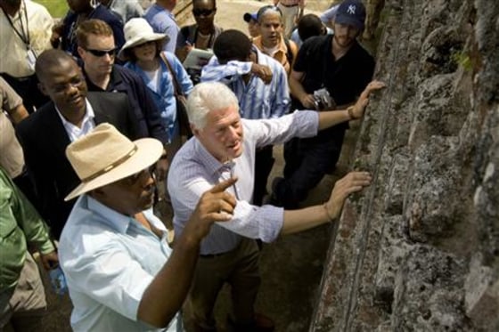 U.N. special envoy to Haiti and former U.S. President Bill Clinton (C) speaks with a local businessman as he visits the ruins of Sans Souci palace near the northern city of Cap Haitian during his two day trip to promote tourism and industry in Haiti in this October 2, 2009 file photo.