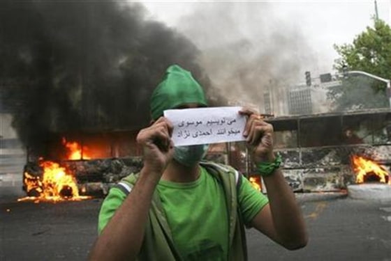 Mousavi supporter holds a piece of paper that reads We write Mousavi, they read Ahmadinejad during post-election unrest in Tehran