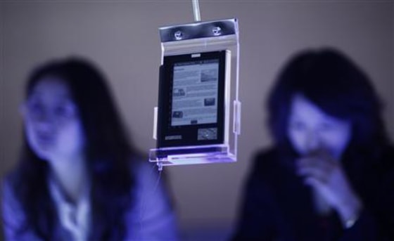 Two women stand behind an e-book at the of Frankfurt book fair