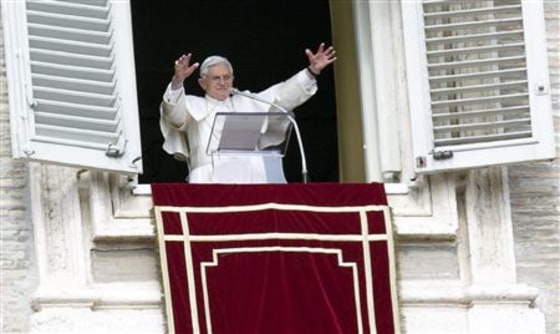 Pope Benedict XVI waves the faithful during the Angelus prayer from a windows of his private apartment at the Vatican