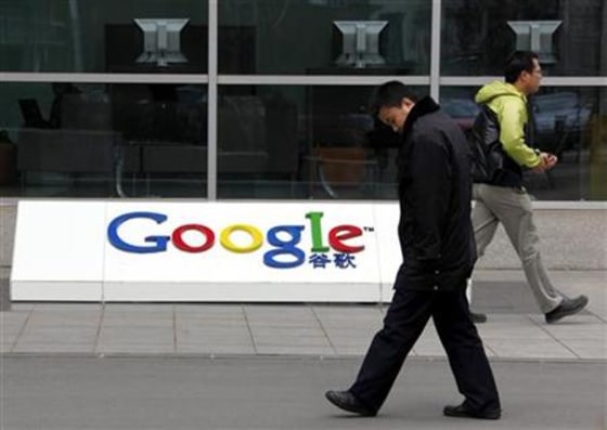 A security guard and an employee walk past Google's logo outside Google China headquarters building in Beijing