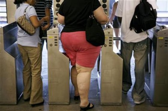 Subway riders walk through the turnstiles while leaving the U.S. Open