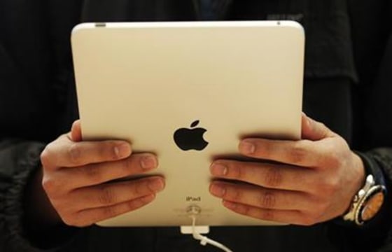 Customer hold the new iPad tablet computer at its UK launch at an Apple store in central London