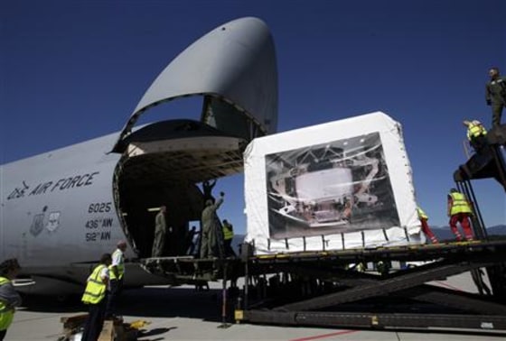 Staff attempt to load the Alpha Magnetic Spectrometer detector into a US Air Force Galaxy aircraft during last preparations at Cointrin Airport in Geneva