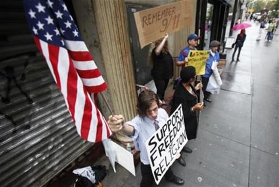 Demonstrators who support and oppose the proposed Park51 stand with signs in front of the site in New York