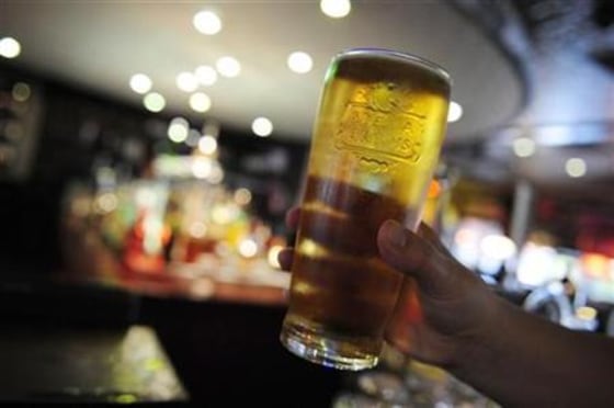 A customer poses for the camera with a pint of beer in a public house in Leeds, northern England