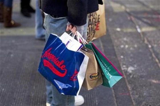 Man holds shopping bags as he stands on 5th Avenue in New York