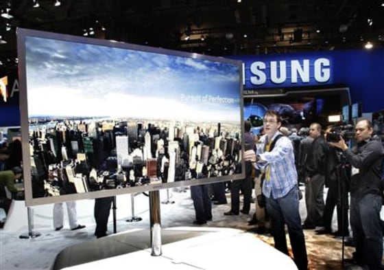 A reporter touches a 75-inch, full HD 3D LED television by Samsung Electronics during the International CES in Las Vegas