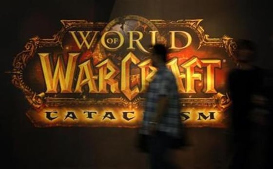 A visitor walks past a placard of 'World of Warcraft' at their exhibition stand at the Gamescom 2010 fair in Cologne
