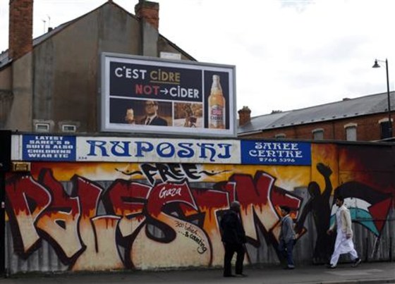 Men walk past political graffiti in the Sparkbrook area of Birmingham