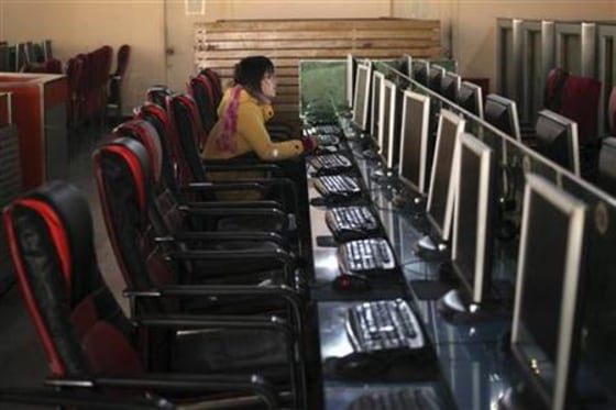 A woman uses a computer in an internet cafe in Shanghai
