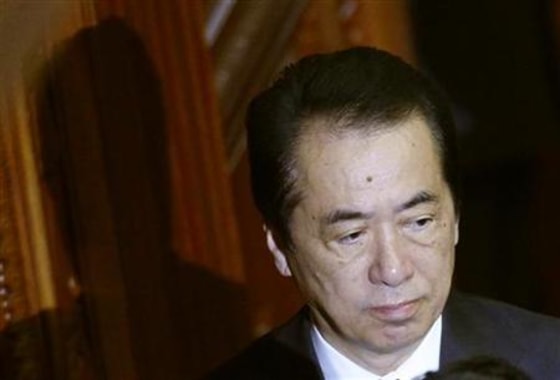 Japanese Prime Minister Kan walks to cast a ballot at the parliament in Tokyo