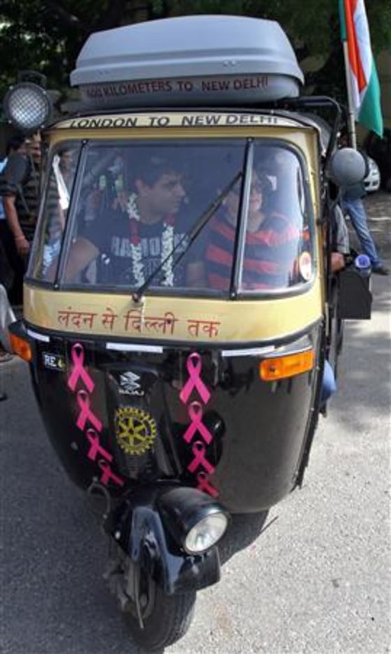 Sharma drives \"Flying Rani,\" a black-and-yellow auto rickshaw with a 175 cc engine, through a street in New Delhi