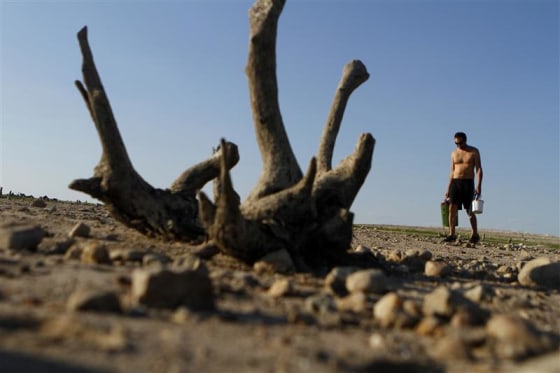 A man walks along Lake Travis after water receded during a drought in Austin, Texas