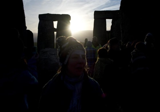 Revellers watch as the sun rises at Stonehenge on Salisbury plain in southern England