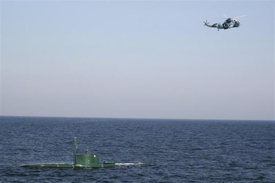 Military helicopter flies over submarine during Velayat-90 war games by Iranian navy in Strait of Hormuz in southern Iran