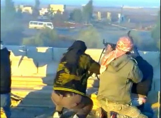 Still image taken from video shows purported members of \"Free Syrian Army\" firing at a convoy of government security buses in the village of Dael
