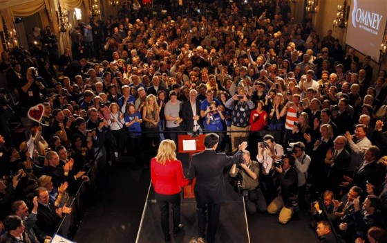 Republican presidential candidate and former Massachusetts Governor Mitt Romney holds hands with his wife Ann as he addresses supporters at his Iowa Caucus night rally in Des Moines
