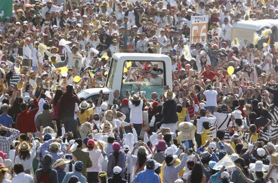 Pope Benedict XVI waves as he arrives in his Popemobile to lead a mass at the Parque del Bicentenario in Silao