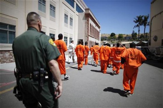 Inmates are escorted by a guard through San Quentin state prison