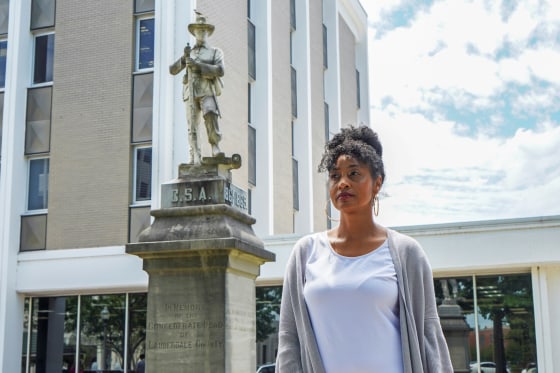 Camille Bennett poses for a photo in front of the confederate statue that she is trying to have moved to the confederate cemetery in Florence, Ala., on May 19, 2021.