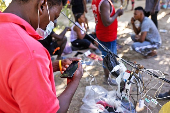 A Haitian immigrant charges his smartphone on Sept. 22, 2021, in Ciudad Acuna, Mexico.