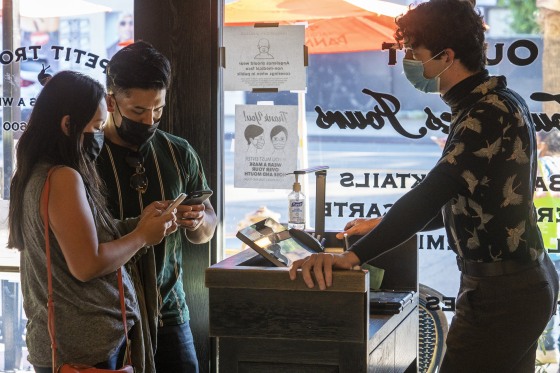 Restaurant host Joey Tyler, right, verifies arriving patrons' vaccination records at French restaurant Petit Trois in Los Angeles on Nov. 5, 2021.