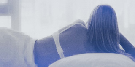 Photo of a woman laying in bed looking out a window.