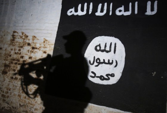 A member of the Iraqi forces walks past a mural bearing the logo of the Islamic State group on March 1, 2017, in the village of Albu Sayf, on the southern outskirts of Mosul.