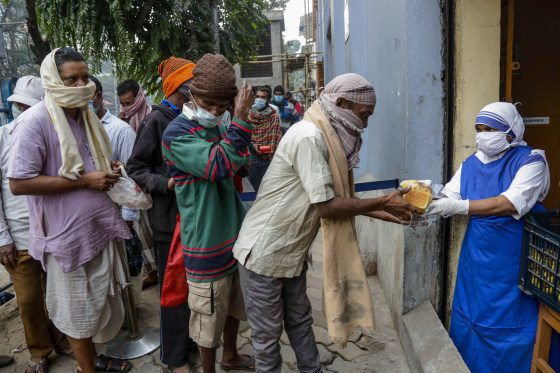 Nuns of Missionaries of Charity distribute food to the poor and needy in Kolkata on Tuesday.