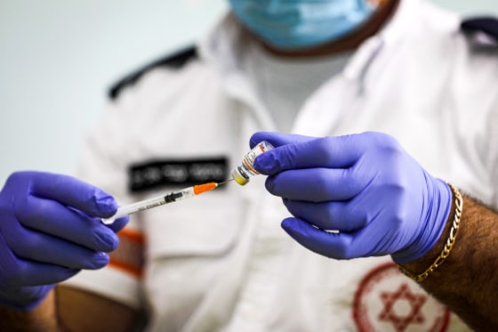 An Israeli health worker administers a dose of the Pfizer-BioNTech Covid-19 vaccine to a student in the Druze village of Majdal Shams in the Israel-annexed Golan Heights, on Dec. 12, 2021.