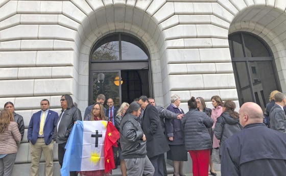 Rosa Soto Alvarez, of Tucson, Ariz., holds a flag of the Pascua Yaqui Tribe as she and other Native Americans stand outside the federal appeals court in New Orleans, on Jan. 22, 2020.