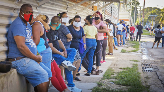 People queue to buy products with U.S. dollars