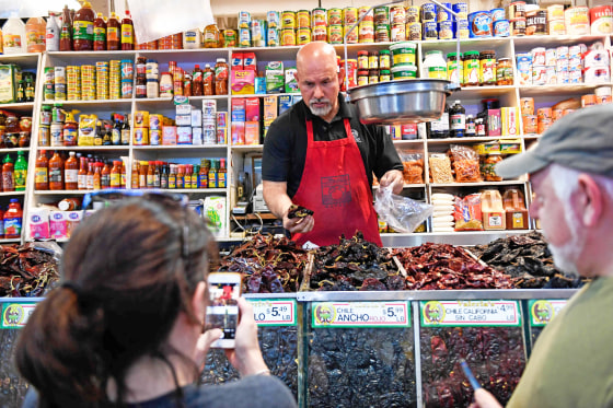 A clerk bags dried peppers