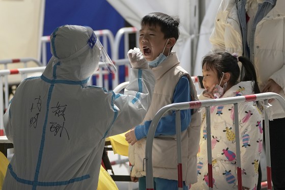 A health worker takes a throat swab sample from a child in Beijing on March 21, 2022.