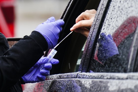 A driver places a swab into a vial at a free drive-thru Covid-19 testing site in Darby, Pa., on Jan. 20.