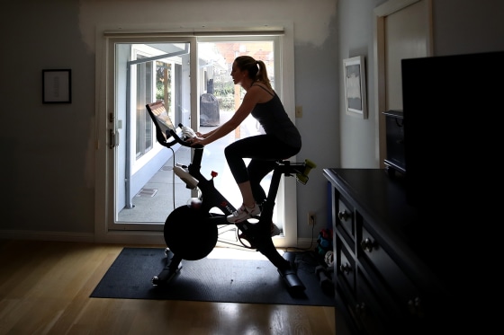 Image: Jen Van Santvoord rides her Peloton exercise bike at home in San Anselmo, Calif., on April 7, 2020.