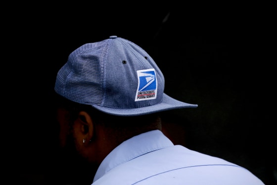 A United States Postal Service worker outside distribution center in Chicago on Oct. 12, 2021.