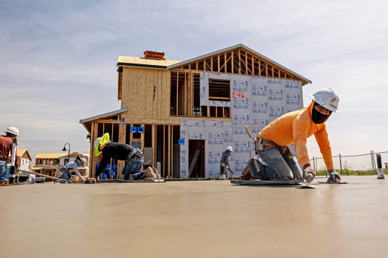 Contractors work on concrete slabs in the Cielo at Sand Creek by Century Communities housing development