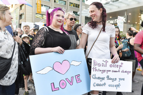 Attendees hold signs during the Trans March