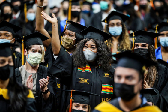 Graduates stand as they are recognized as the first members of their families to graduate college, at the University of Massachusetts Boston on Aug. 26, 2021.