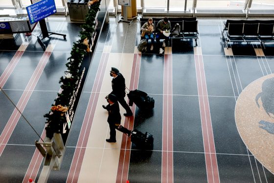 Airline pilots walk through Ronald Reagan Washington National Airport on Dec. 27, 2021, in Arlington, Va.