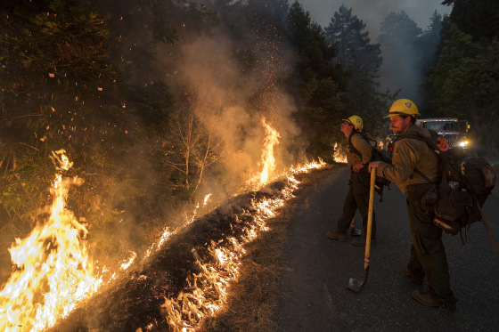 Firefighters monitor a controlled burn along Nacimiento-Fergusson Road to help contain the Dolan Fire near Big Sur, Calif., on Sept. 11, 2020.