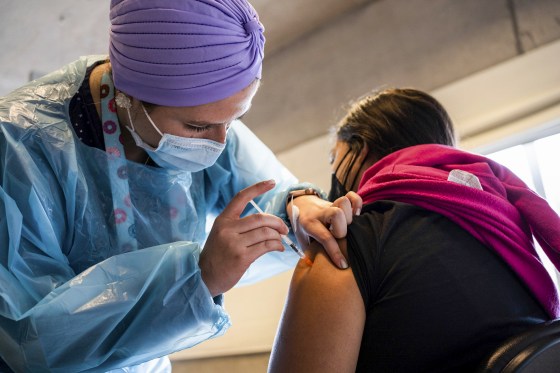 A health care worker administers a dose of the Pfizer-BioNTech Covid-19 vaccine on Feb. 11, 2022.
